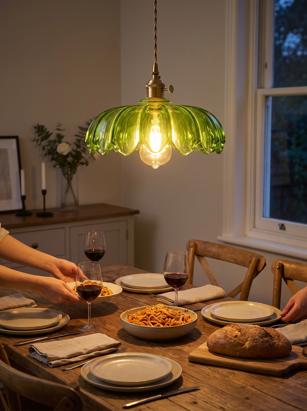 Flower glass pendant glowing over a dinner table